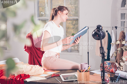 Image of Fashion designers working in studio sitting on the desk