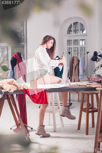 Image of Fashion designers working in studio sitting on the desk