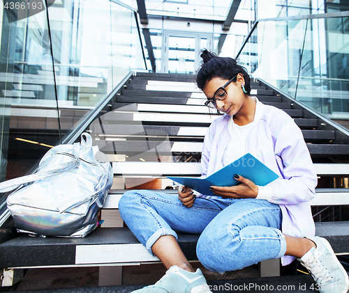 Image of young cute indian girl at university building sitting on stairs 