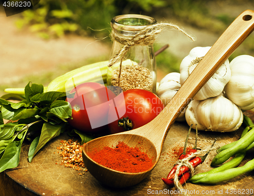 Image of vegetables on wooden kitchen with spicies, tomato, chilli, green