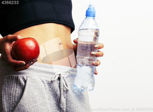 Image of close up woman stomach with hands holding water and reg apple