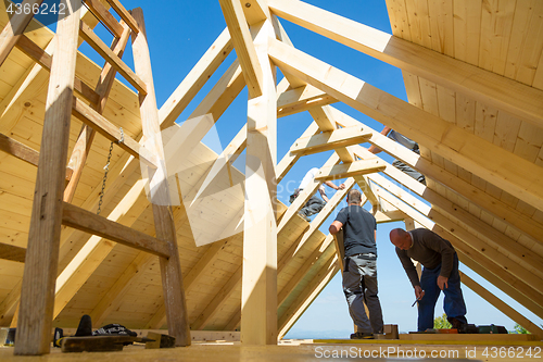 Image of Builders at work with wooden roof construction.