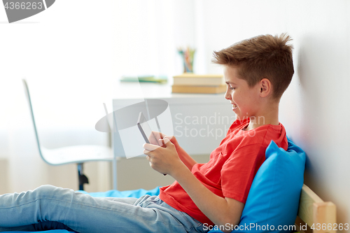 Image of smiling boy with tablet pc computer at home