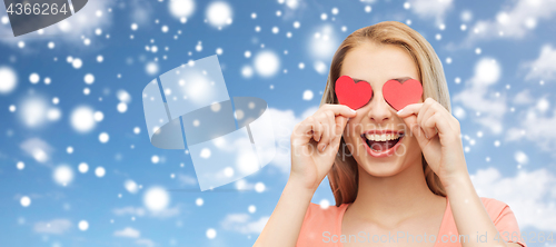 Image of happy young woman with red heart shapes on eyes