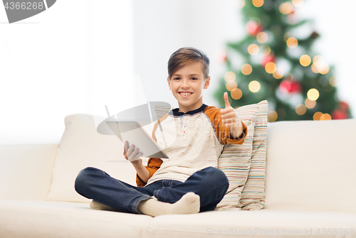 Image of boy with tablet pc showing thumbs up at christmas