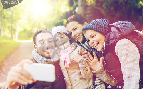 Image of family with backpacks taking selfie by smartphone