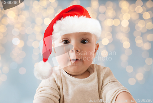 Image of close up of little baby in santa hat at christmas