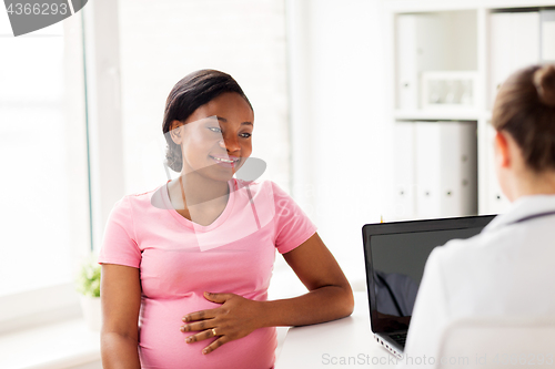 Image of doctor with laptop and pregnant woman at clinic