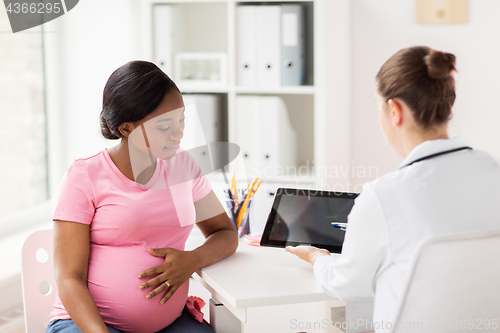 Image of doctor with tablet pc and pregnant woman at clinic