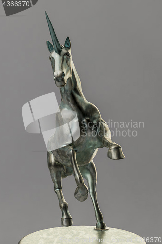 Image of a beautyful bronze unicorn figure isolated on gray background