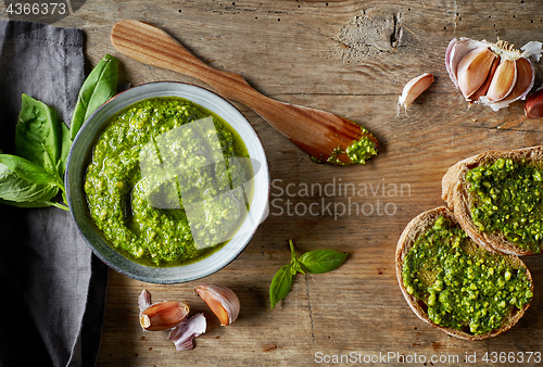 Image of Bowl of basil pesto on wooden table