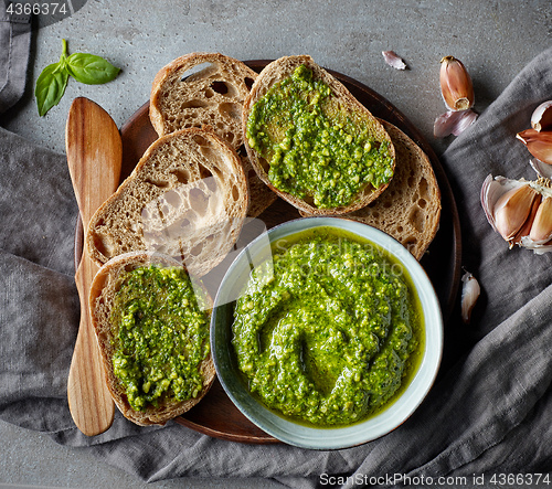 Image of Bowl of basil pesto on grey table