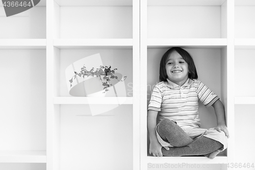 Image of young boy posing on a shelf