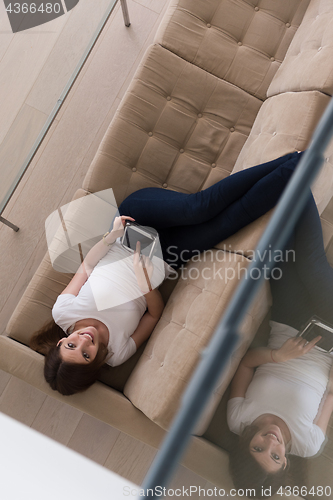 Image of woman on sofa using tablet computer