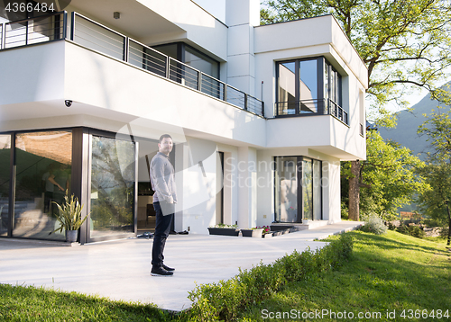 Image of man in front of his luxury home villa