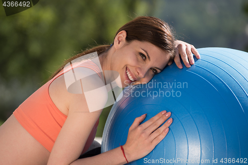 Image of woman doing exercise with pilates ball