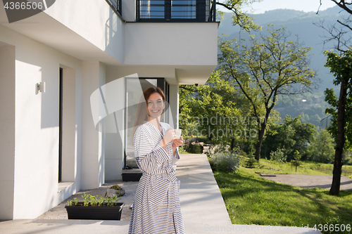 Image of woman in a bathrobe enjoying morning coffee