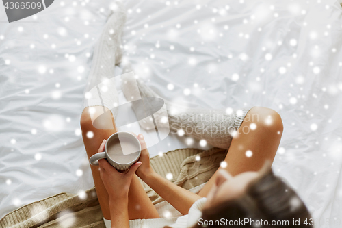 Image of close up of woman with cocoa cup in bed at home