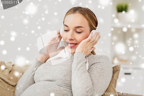 Image of pregnant woman with headphones listening to music