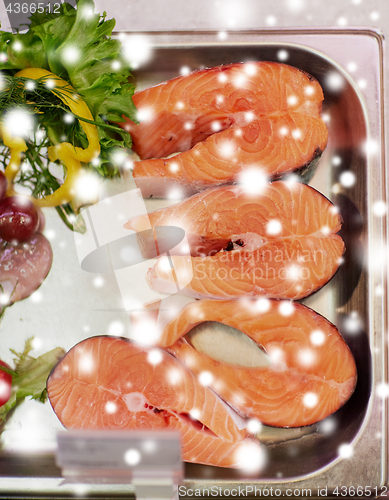 Image of salmon fish fillet in metal tray on ice at grocery