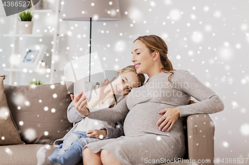 Image of pregnant woman and girl taking smartphone selfie