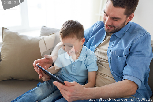 Image of father and son with tablet pc playing at home