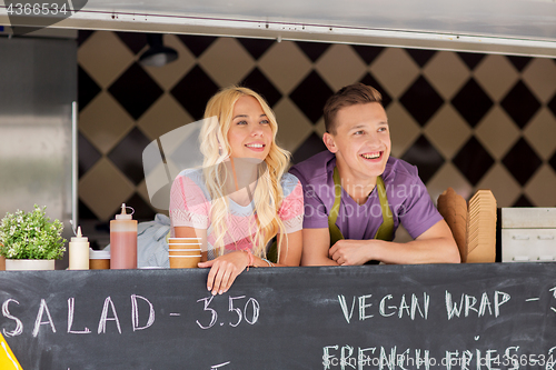 Image of happy young sellers at food truck