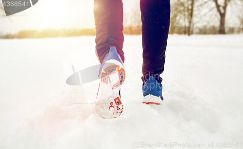 Image of close up of feet running along snowy winter road