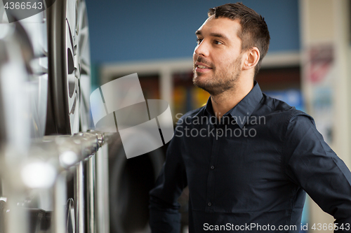 Image of male customer choosing wheel rims at car service