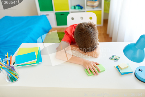 Image of tired or sad student boy with smartphone at home