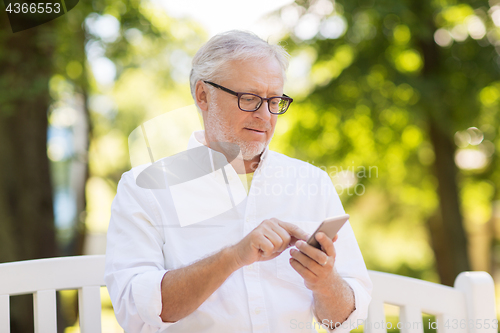 Image of senior man with smartphone at summer park