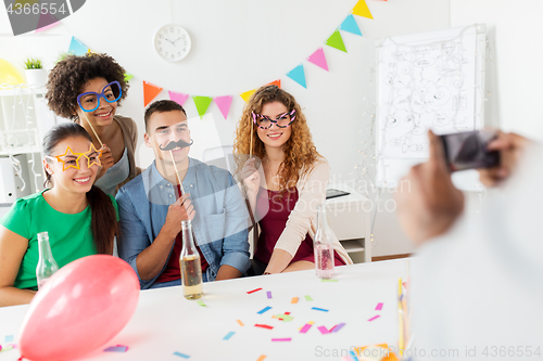 Image of friends or team photographing at office party