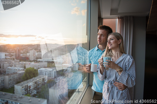 Image of young couple enjoying evening coffee by the window