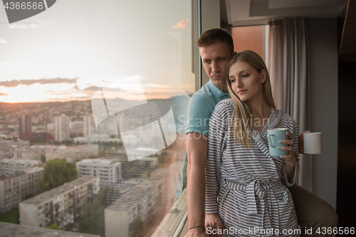 Image of young couple enjoying evening coffee by the window