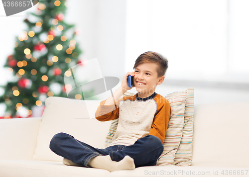 Image of boy calling on smartphone at home at christmas