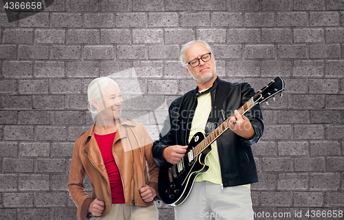 Image of happy senior couple with electric guitar