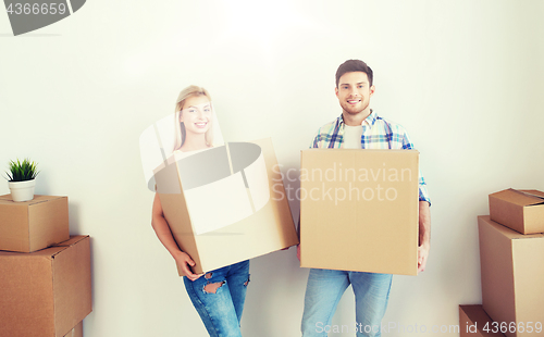 Image of smiling couple with big boxes moving to new home