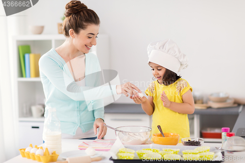 Image of happy mother and daughter baking at home