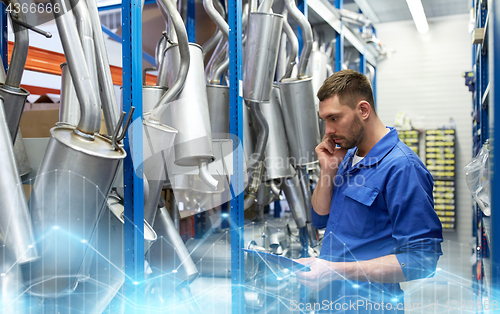 Image of auto mechanic calling on phone at car shop