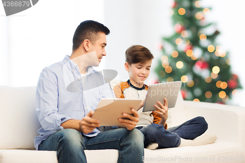Image of happy father and son with tablet pc at christmas