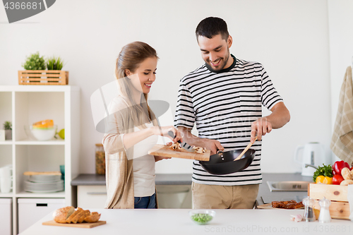 Image of couple cooking food at home kitchen