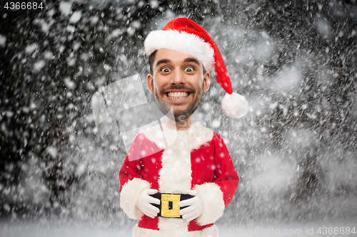 Image of man in santa claus costume over christmas snow