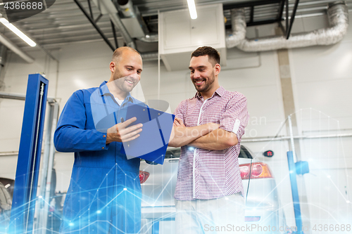 Image of auto mechanic with clipboard and man at car shop