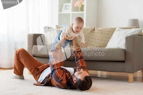 Image of happy father with little baby boy at home