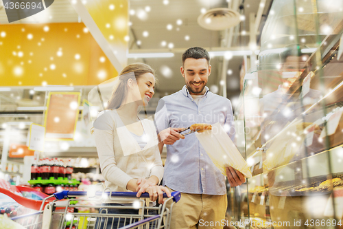 Image of happy couple with shopping cart at grocery store