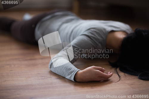 Image of dead woman body lying on floor at crime scene