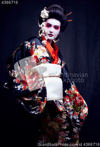 Image of young pretty geisha in kimono with sakura and decoration