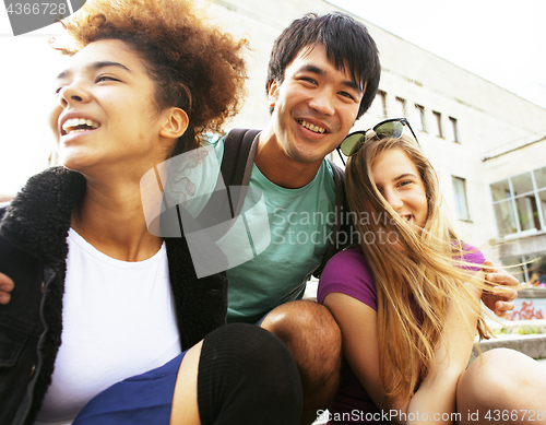 Image of cute group of teenages at the building of university with books huggings, back to school