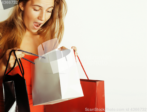 Image of young pretty blond woman with bags on Christmas sale in red dress isolated white