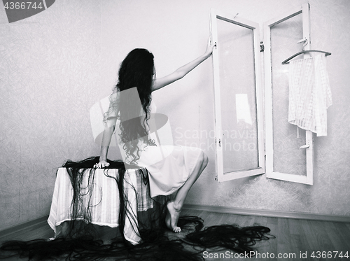 Image of beauty girl cuting her hair in empty fearing room halloween ghost